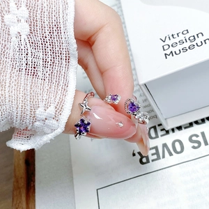 Detailed macro view of silver star and heart rings with purple zircon stones on a white box