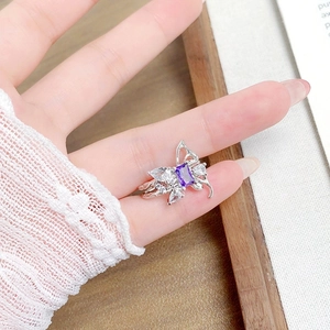 Detailed macro of a silver butterfly ring with a purple zircon and double open bands