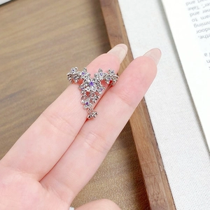 Detail of silver floral ring with purple zircon crystals worn on a finger