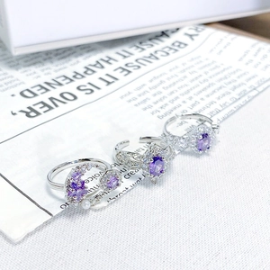 Detailed close-up of three adjustable silver rings with purple zircons and moon charms