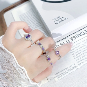 Set of silver geometric rings featuring purple cubic zirconia and sparkling star accents