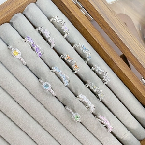 Detail view of assorted butterfly and square colorful zircon rings in jewelry box