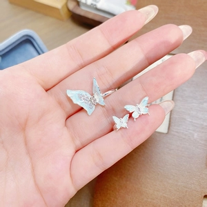 Détail de bagues papillon en argent avec émail bleu portées sur la main