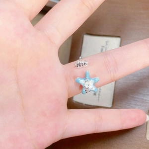 Détail macro de l'étoile de mer en émail et du coquillage sur bague réglable