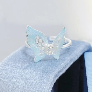 Détail d'une bague papillon en émail bleu avec zircons sur une boîte à bijoux