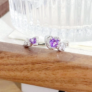 Detailed view of silver open ring featuring purple heart-shaped zircon stones and tiny diamonds