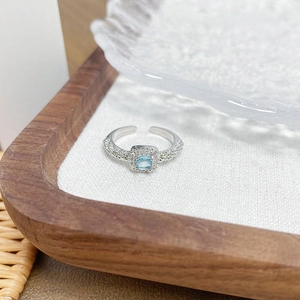 Macro detail of square blue gemstone ring with sparkling pavé cubic zirconia setting