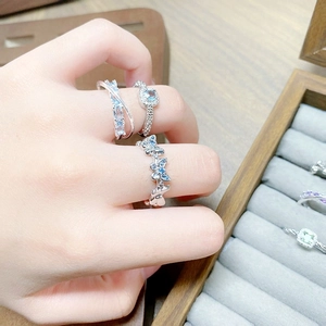 Close-up of elegant silver butterfly and square cubic zirconia rings on model finger