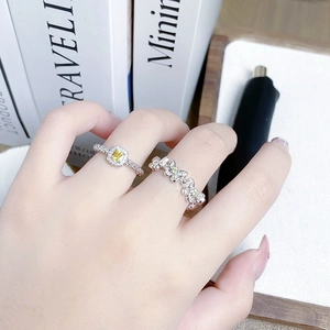 Detailed shot of yellow gemstone square ring and silver butterfly ring on hand