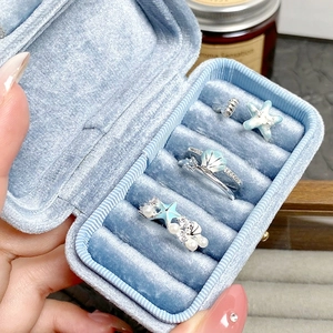 Bague étoile de mer en émail avec perles dans un écrin de bijoux en velours bleu