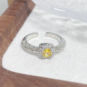 Detailed macro view of an adjustable silver ring with yellow square zircon and crystals