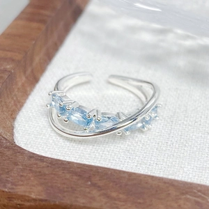Macro detail of silver open ring with five marquise-cut light blue zircon gemstones