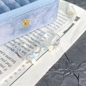 Macro d'une bague étoile de mer argentée avec émail bleu, perles et zircones