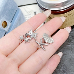 Vue détaillée de bagues en argent avec étoiles de mer, coquillages et zircons