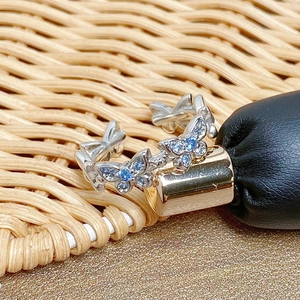 Close-up of butterfly open ring featuring light blue and clear cubic zirconia stones