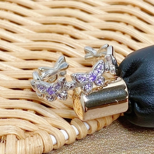 Macro shot of silver ring featuring purple zircon butterfly cluster and pavé setting