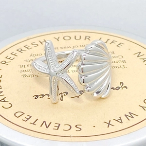 Vue macro de la bague en argent avec étoile de mer et coquillage aux détails émaillés