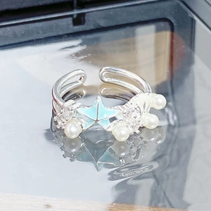 Vue macro de la bague étoile de mer avec émail bleu et perles blanches sur miroir