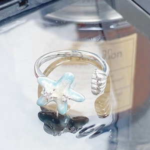 Détails de motifs d'étoile de mer et coquillage sur une bague ajustable en émail argenté