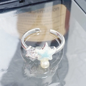 Détail macro de la bague étoile de mer avec émail bleu, zircon et perle d'imitation