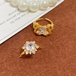 Gros plan de bagues dorées vintage avec zircons géométriques sur fond de velours