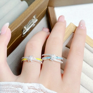 Detailansicht der Emaille-Ringe mit Zirkonia-Pavé auf einem hölzernen Displayständer