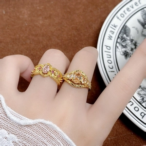 Détail d'une bague vintage en or avec pierre ovale rose et micro-cristaux rouges incrustés