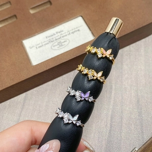 Detailed macro shot of zircon butterfly open rings in various finishes and enamel colors