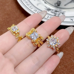 Bagues dorées vintage géométriques avec cristaux de zircon sur la main d'un modèle