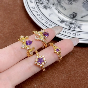Détail d'un ensemble de quatre bagues dorées vintage avec zircons violets et blancs