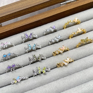 Detail view of colorful zircon butterfly rings in a velvet display case