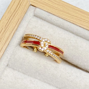 Detaillierte Makroansicht des vergoldeten roten Emailleknoten-Rings mit Zirkonia in der Box