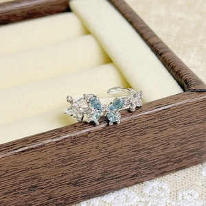 Macro shot of silver butterfly ring with blue pear-cut gems and micro-pave details