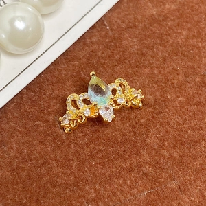 Détail macro de bague couronne dorée avec pierre bleue goutte et micro pavé