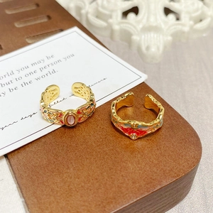 Detailed close-up of vintage gold rings with enamel floral patterns and gemstones
