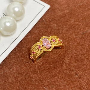 Gros plan détaillé d'une bague dorée vintage avec pierre rose et travail ajouré