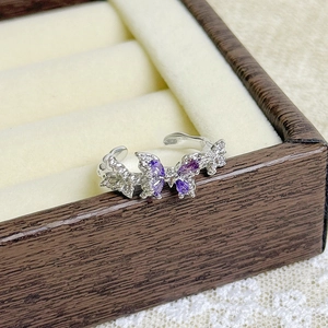 Detailed close-up of butterfly ring with purple gemstones and shimmering crystals