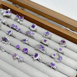 Elegant purple zircon rings with flower and butterfly designs on velvet jewelry tray