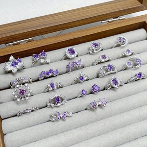 Exquisite silver-colored ring set with purple zircon gemstones in various floral designs