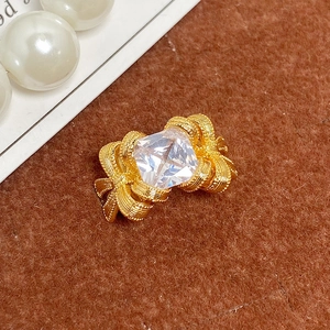 Vue macro d'une bague nœud dorée avec un zircon cubique transparent de taille carrée