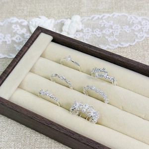 Close-up of a 6-piece silver ring set with zircons and floral designs on a jewelry tray