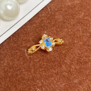 Gros plan d'une bague vintage en or avec pierre bleue ovale et détails en micro-pavé