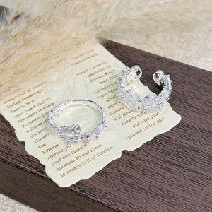 Detailed close-up of two silver rings with branch texture and butterfly hollow design
