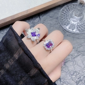 Detailed shot of two elegant silver rings with purple zircon and sparkling floral designs