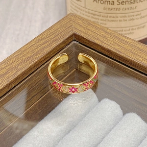 Detailed macro view of vintage enamel flower ring on a wooden jewelry display