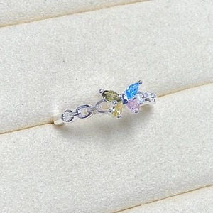 Detail of silver chain ring featuring a butterfly motif set with colorful marquise zircons