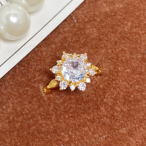 Gros plan sur une bague vintage dorée avec fleur géométrique et micro-pavage