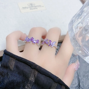 Close-up of sparkling purple zircon rings with butterfly and rectangle stone designs