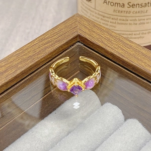 Macro detail of vintage gold floral ring featuring a square purple gemstone setting