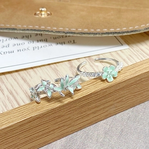 Détail de bagues papillon en émail vert menthe avec perles et cristaux brillants